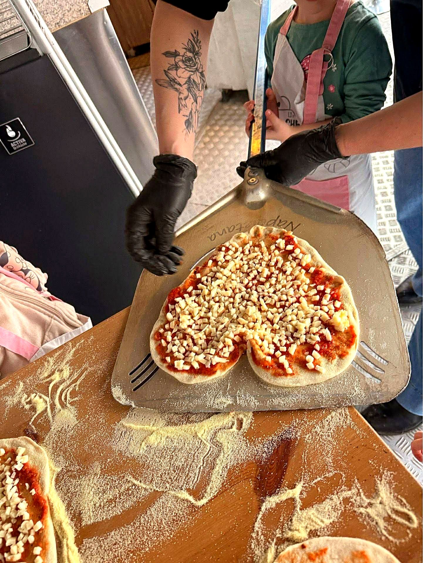 Pizza w kształcie serca przygotowana przed wsadzeniem do pieca